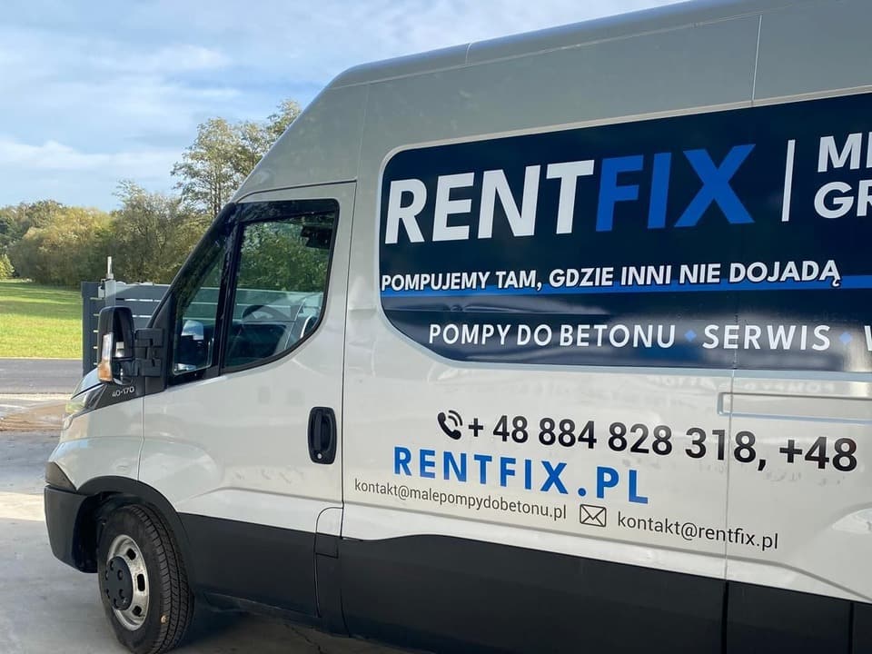 Srebrny bus z ciemnym panelem RENTFIX, hasłem Pompujemy tam, gdzie inni nie dojadą, numerem telefonu i adresem rentfix.pl, widok z przodu pod kątem.